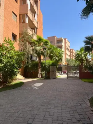 a brick driveway with palm trees in front of a building at Luxury Apartment in Central Marrakech - Pool & Fast Wi-Fi in Marrakech