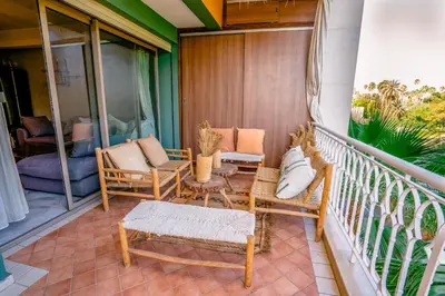 a balcony with chairs and a table on a porch at vue imprenable sur les jardins de la villa d Yves saint Laurent in Marrakech