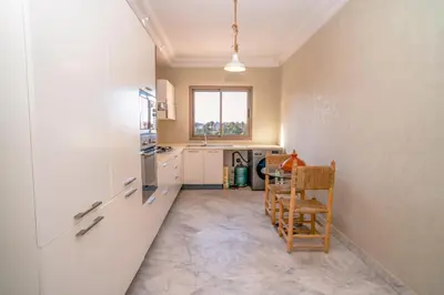 a kitchen with a table and chairs in a room at vue imprenable sur les jardins de la villa d Yves saint Laurent in Marrakech