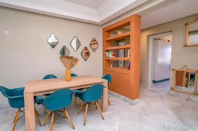 a dining room with a wooden table and blue chairs at vue imprenable sur les jardins de la villa d Yves saint Laurent in Marrakech