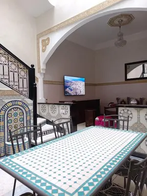 a dining room with a table and chairs and a tv at MARRAKECh TYPICAL HOUSE MAISON TYPIQUE MARRAKECH G2 40 in Marrakech