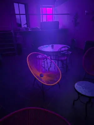 a room with tables and chairs with purple lights at El Méhénni Guéliz JACUZZI 6 Personnes Terrasse Privative in Marrakech
