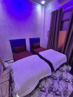 two beds in a room with purple lights at El Méhénni Guéliz JACUZZI 6 Personnes Terrasse Privative in Marrakech