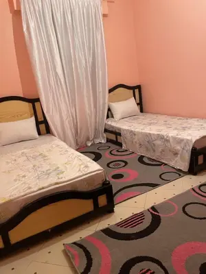 two beds in a room with a rug at Jolie appartement à Marrakech in Marrakech