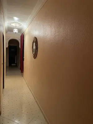 a hallway with a tile floor and a clock on the wall at Jolie appartement à Marrakech in Marrakech