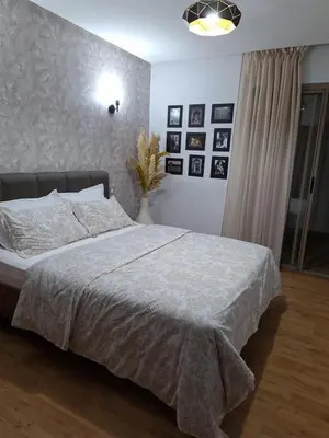 a bedroom with a bed and a wall with pictures at Bel appartement à Marrakech dans la résidence Pearl Garden avec piscine située sur la route de Casablanca Sa grande terrasse a une splendide vue sur la ville et les montagnes de l'Atlas A quelques minutes du centre ville et du grand Stade de Marrakech in Marrakech