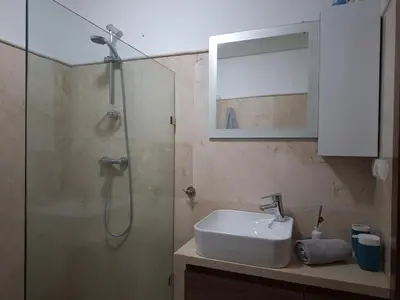 a bathroom with a shower and a sink at Bel appartement à Marrakech dans la résidence Pearl Garden avec piscine située sur la route de Casablanca Sa grande terrasse a une splendide vue sur la ville et les montagnes de l'Atlas A quelques minutes du centre ville et du grand Stade de Marrakech in Marrakech