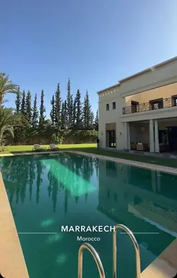 a swimming pool in front of a house at Villa Lemaire in Marrakech