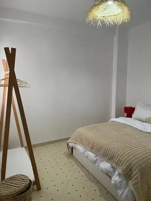 a bedroom with a bed and a chandelier at Aeroport appartement in Marrakech