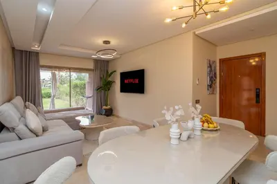a living room with a white table and a couch at Prestigia agate vue sur golf in Marrakech