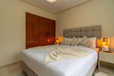 a bedroom with a large white bed with two lamps at Prestigia agate vue sur golf in Marrakech
