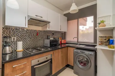 a kitchen with a washer and a washing machine at Prestigia agate vue sur golf in Marrakech