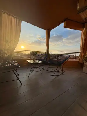 a balcony with chairs and a table and a view of the ocean at Kech Aliouni in Marrakech