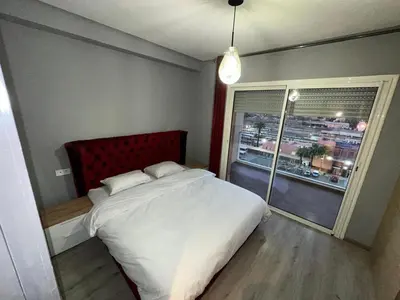 a bedroom with a large white bed and a window at Appartement 2 chambres Atr67 Hivernage in Marrakech