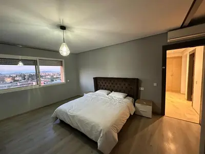 a bedroom with a large bed and a large window at Appartement 2 chambres Atr67 Hivernage in Marrakech