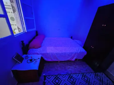 a purple bedroom with a bed and a table at Angel 12 minutes from Marrakech airport in Marrakech