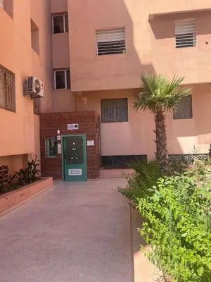 a building with a green door and a palm tree at Calm & Cozy Studio with Balcony in Marrakech