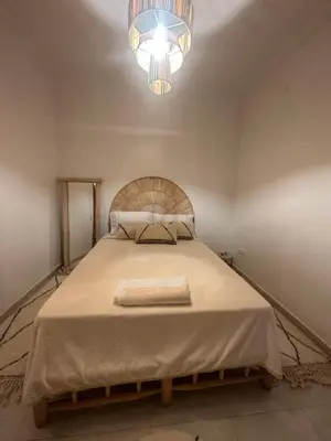 a bedroom with a large bed with a chandelier at A flat near the airport in Marrakech