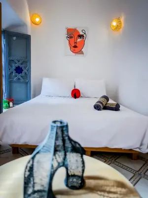 a bedroom with a bed with a mask on the wall at Riad bleu 4 in Marrakech
