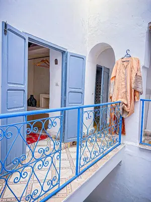 a balcony with a blue railing and a shirt on a rack at Riad bleu 4 in Marrakech