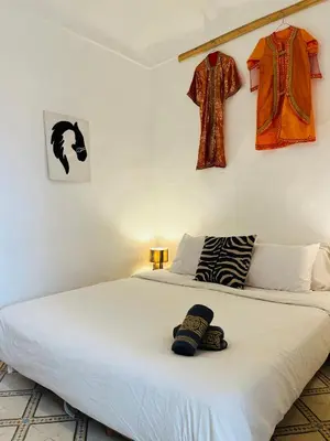 a bedroom with a large white bed with hats on it at Riad bleu 4 in Marrakech