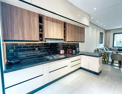 a kitchen with white cabinets and a black counter top at Villa Stayvi 1 Heated Pool Bliss in Marrakech
