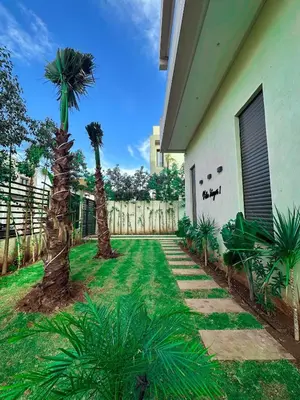 a yard with two palm trees next to a house at Villa Stayvi 1 Heated Pool Bliss in Marrakech