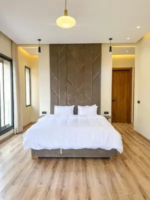 a bedroom with a large white bed and wooden floors at Villa Stayvi 1 Heated Pool Bliss in Marrakech