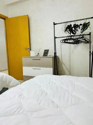 a bedroom with a white bed and a desk and a closet at Bright downtown apartment in Marrakech