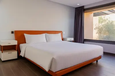 a bedroom with a large white bed and a window at Atelier Loft Oliver Palm Resort in Marrakech