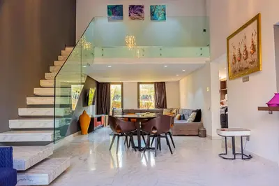 a living room with a staircase and a table and chairs at Atelier Loft Oliver Palm Resort in Marrakech