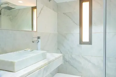 a white bathroom with a sink and a shower at Atelier Loft Oliver Palm Resort in Marrakech