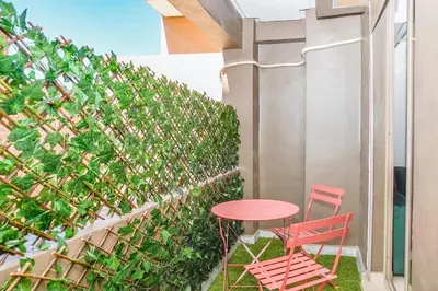 a table and two chairs on a balcony with a green hedge at Lux Oasis - Marrakech Center in Marrakech
