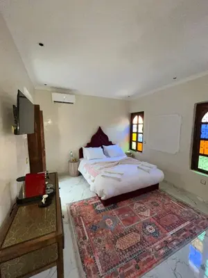 a bedroom with a large bed and a rug at Riad Abrare in Marrakech
