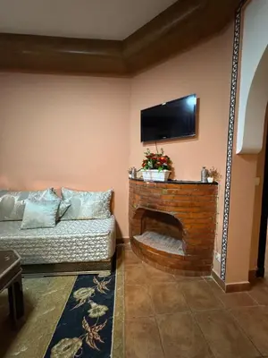 a living room with a couch and a flat screen tv at Dream stay 5 swimming pools for family in Marrakech