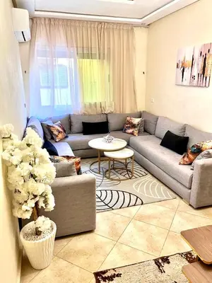 a living room with a couch and a table at Appartement Marrakech 2 chambres Residence al Manar in Marrakech