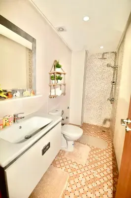 a white bathroom with a toilet and a sink at Appartement Marrakech 2 chambres Residence al Manar in Marrakech