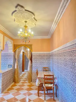 a dining room with blue tiled walls and a table and chairs at Appartement, Marrakech cosy & traditionnel in Marrakech