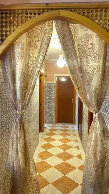 an arched doorway with a curtain in a hallway at Appartement, Marrakech cosy & traditionnel in Marrakech