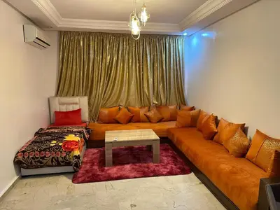 a living room with a couch and a table at Le Chaleureux avec Balcon 8 face gare CTM Hivernage in Marrakech