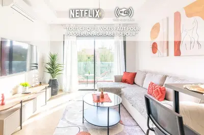 a living room with a couch and a table at Livia cosy - Clim, Wifi, Jardin à 10min de l'Aéroport in Marrakech