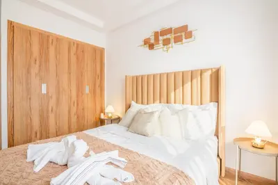 a bedroom with a large white bed with white sheets at Livia cosy - Clim, Wifi, Jardin à 10min de l'Aéroport in Marrakech