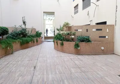 a courtyard with plants and a person walking into a building at Appart Opera Prestige Détente Moderne in Marrakech