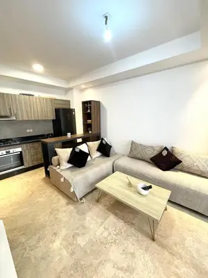 a living room with a couch and a coffee table at Ana cosy - Clim, Wifi, Jardin à 10min de l'Aéroport in Marrakech