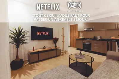 a living room with a tv and a kitchen at Eva cosy - Clim, Wifi, Jardin à 10min de l'Aéroport in Marrakech