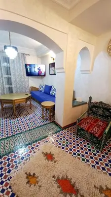 a living room with a blue couch and a table at Charming Oasis in Marrakesh in Marrakech
