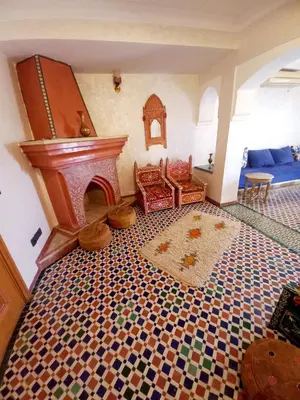 a living room with a fireplace and a tiled floor at Charming Oasis in Marrakesh in Marrakech