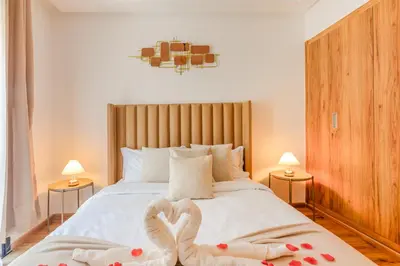 a bedroom with a bed with two swans shaped towels at Lina cosy - Clim, Wifi, Jardin à 10min de l'Aéroport in Marrakech