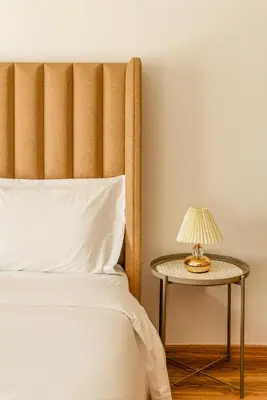 a bed with a side table with a lamp on it at Maeva cosy - Clim, Wifi, Jardin à 10min de l'Aéroport in Marrakech