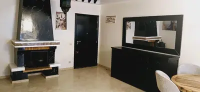 a living room with a fireplace and a black door at Gueliz apartment 2 chambres Marrakech in Marrakech